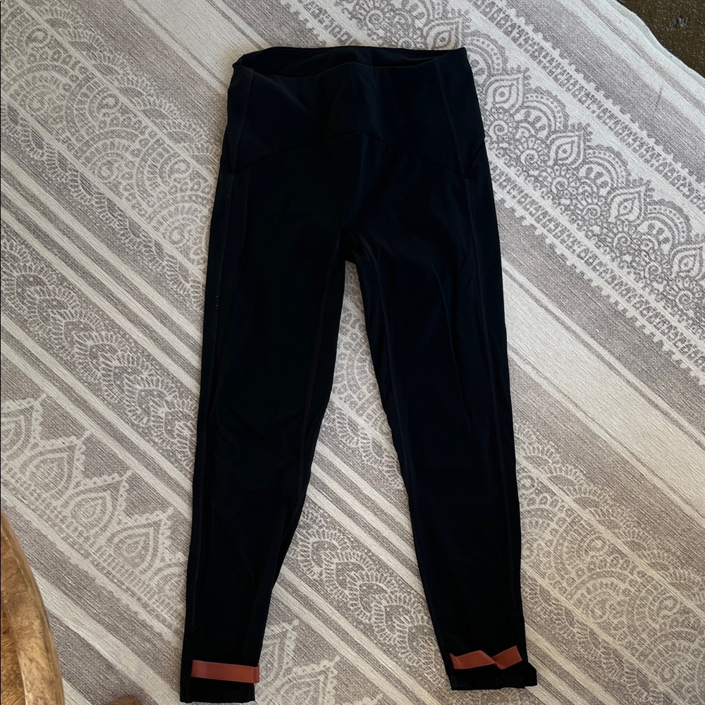 ZYIA Black Active Leggings with elastic strap detail at bottom.